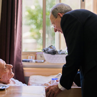 Supreme Chaplain Archbishop William Lori visits with a resident of the St. Nicholas Home in Beit Jala on Sept. 4. (Photo by George Jaraiseh)
