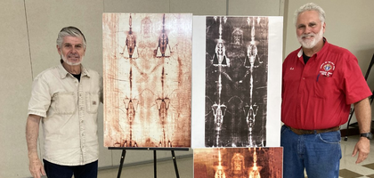 Christopher Rogers (right), faith director of Counsel of the Holy Spirit Council 18557 in Mims, Fla., and Fernando Figueredo, a member of several academic groups studying the Shroud of Turin, stand beside images of the shroud at Holy Spirit Parish after a presentation by Figueredo. Council 18557 sponsored the lecture and a potluck afterward, which was attended by more than 100 people.
