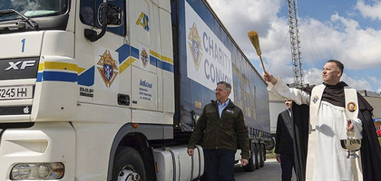 Supreme Knight Patrick Kelly watches as a priest blesses a Knights of Columbus truck bearing aid for Ukraine.