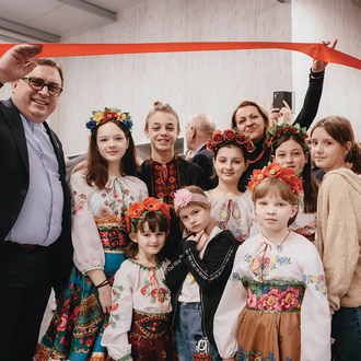 Father Marek Bator and a group of Ukrainian children celebrate the opening of a new school for orphans