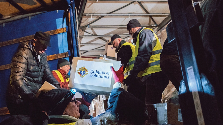 Knights load boxes of aid into a K of C Solidarity Shuttle