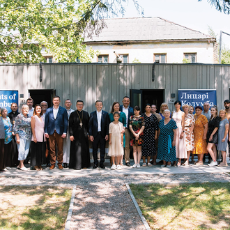 Displaced families and other guests gather in front of modular homes in Briukhovychi, Ukraine, on July 12, 2024. 