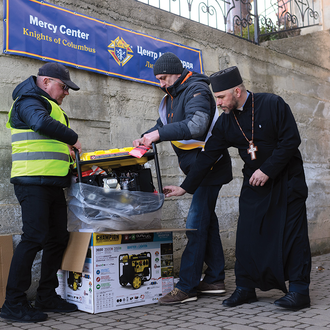 Members of St. Demetrius Council 17293 unpack a generator at Transfiguration of Our Lord Parish in Ivano-Frankivsk.