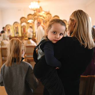 A woman holds her daughter during a Divine Liturgy organized by Holy Martyr Josaphat Council 18318 for families of fallen soldiers