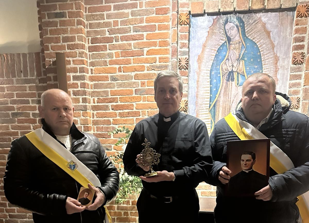Two Knights and a priest stand with an image of Our Lady of Guadalupe during a prayer ceremony