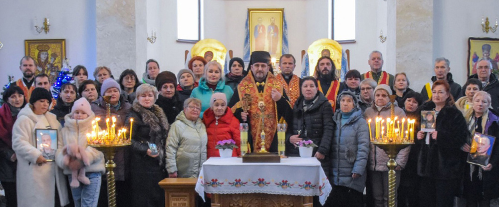 Bishop Mykhaylo Bubniy, exarch of Odesa, Ukraine, and state chaplain of the country’s Ukrainian Greek Catholic Knights, stands with widows, Knights and priests from the Odesa deanery in Pivdenne, Ukraine, during a Christmas liturgy and dinner hosted by the Knights in December.
