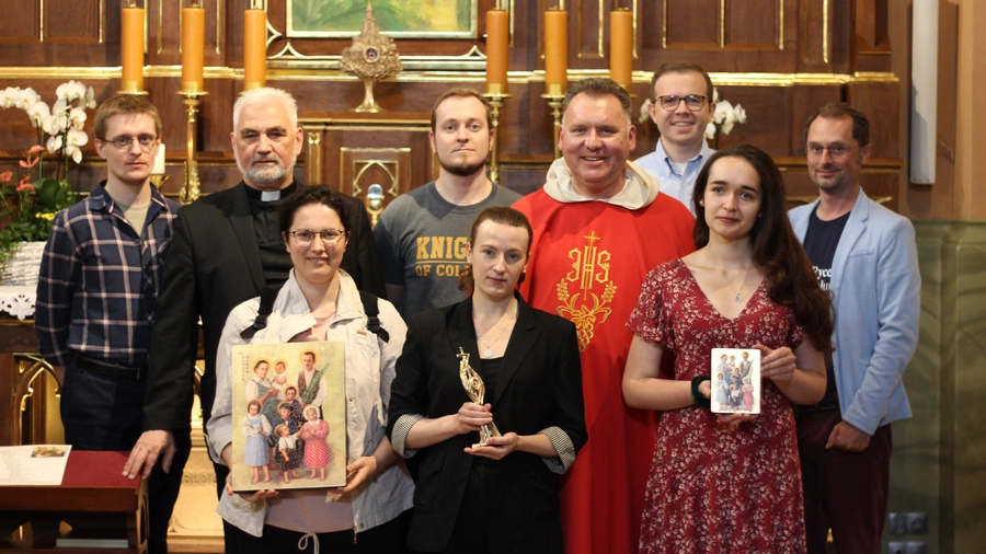 Members of the Knights of Columbus Kraków office in front of the altar containing the remains of the Ulma family at St. Dorothy Church.