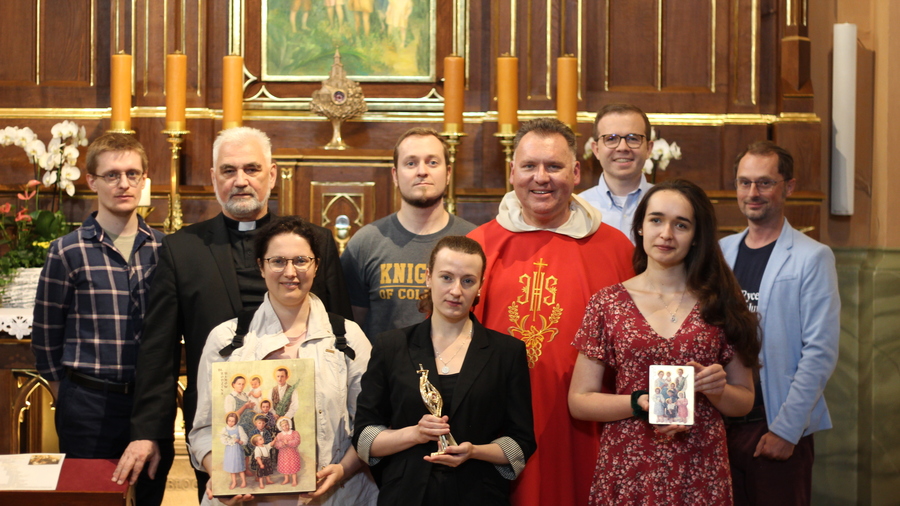 Members of the Knights of Columbus Kraków office in front of the altar containing the remains of the Ulma family at St. Dorothy Church.
