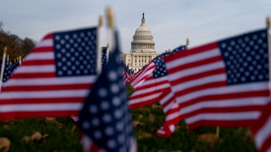 Flags wave in front of the United States Capitol building in Washington, D.C.