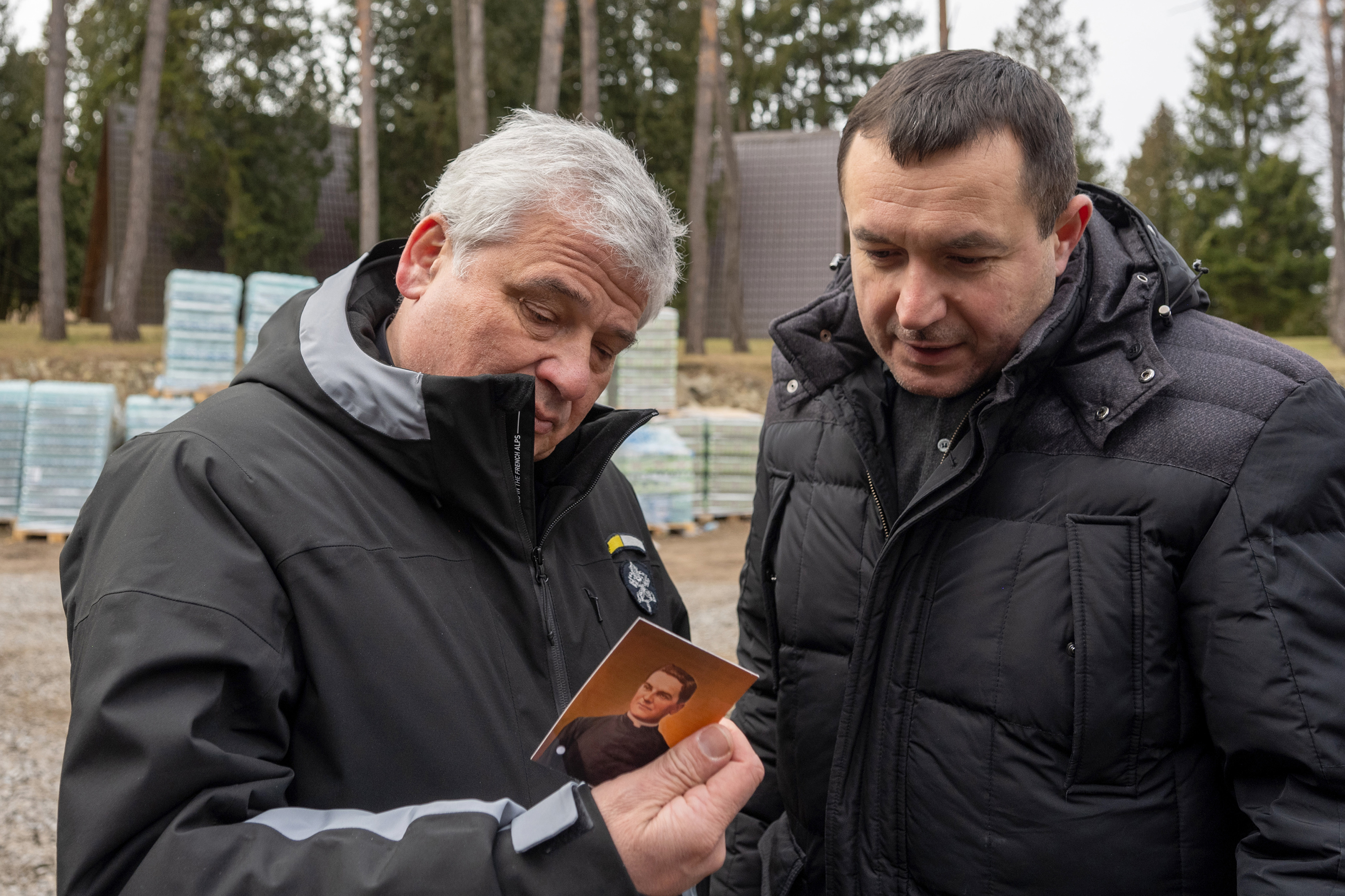 Cardinal Konrad Krajewski and then-State Deputy Yuriy Maletskiy examine a holy card of Blessed Michael McGivney.