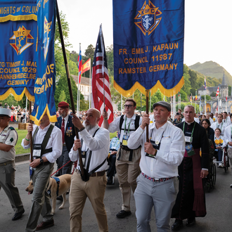 Members of Knights of Columbus military councils and assemblies in Germany carry banners during the Marian candlelight procession in Lourdes, France.