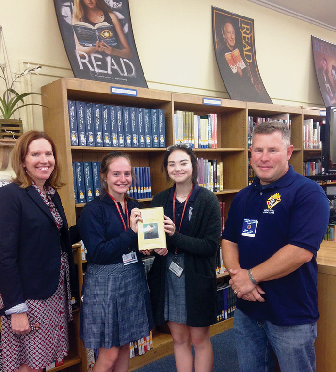 Two female winners of the KofC catholic citizenship essay contest with their sponsors.