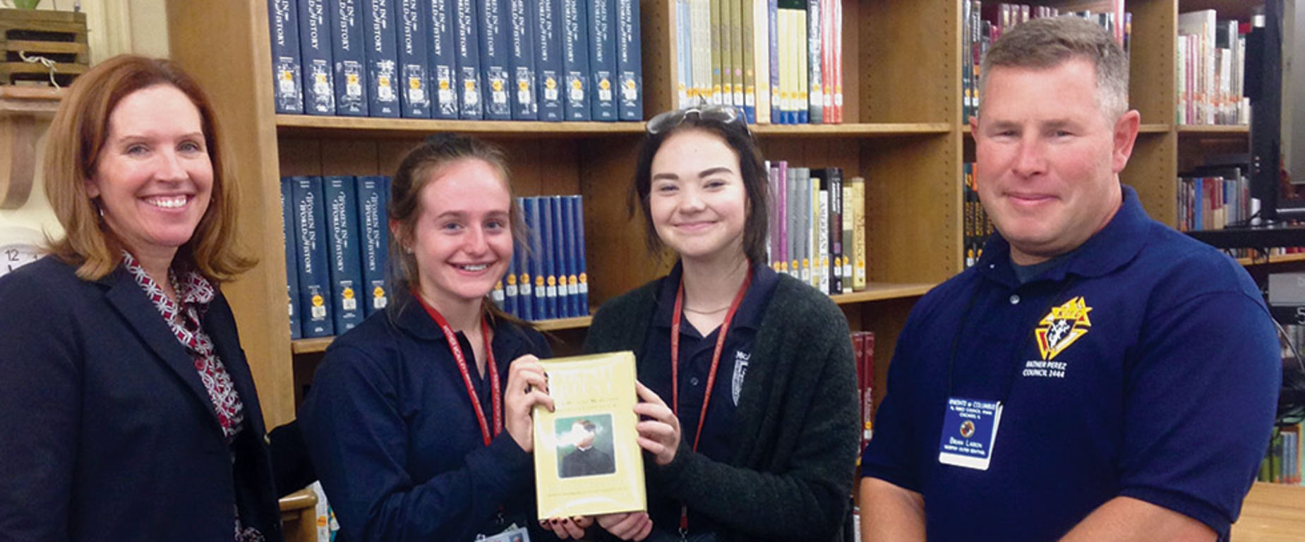 Two female winners of the KofC catholic citizenship essay contest with their sponsors.
