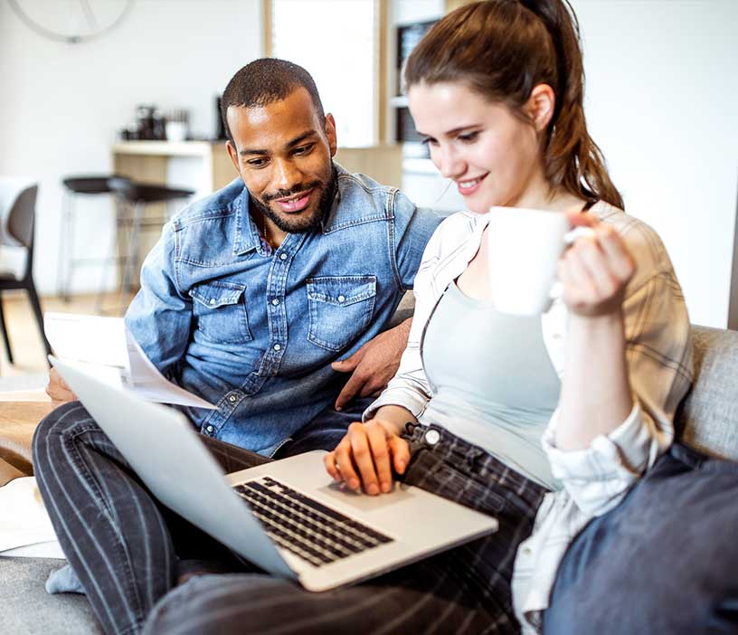 Two people reading a laptop together.