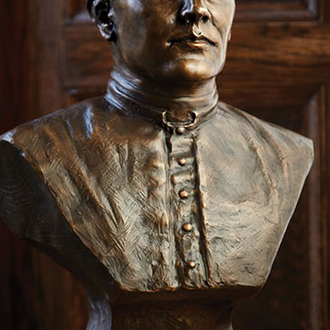 A bronze bust of Father McGivney show a stoic and strong expression on his face.