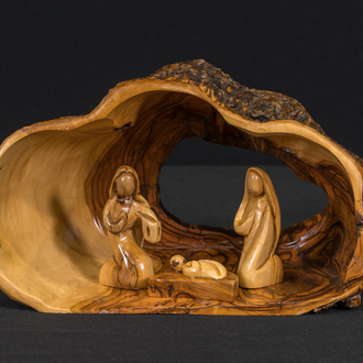 A hollowed-out portion of an olive tree trunk serves as the stable for this crèche and contains the Holy Family.