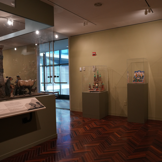 Photo of a museum gallery with Nativity scenes on exhibit.