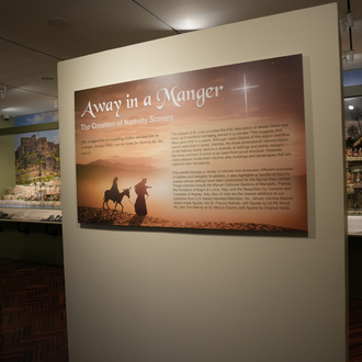 Photo of a museum gallery with Nativity scenes on exhibit.