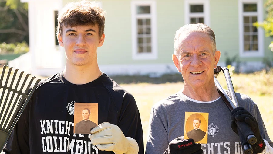 Joe McGivney and his son, Colin, hold cards with the prayer for the canonization