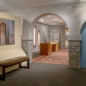 Photo of exhibit gallery featuring Nativity scenes in a faux stone castle setting inspired the architecture of Glencairn Museum.