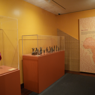 Photo of a museum gallery with Nativity scenes from Africa on exhibit. 