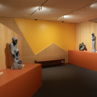 Photo of a museum gallery stone sculptures of the Holy Family and the Madonna & Child on exhibit.
