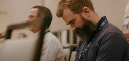 Knight head down, eyes closed praying at a Cor meeting