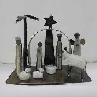 Photo of a serpentine stone and metal Nativity scene featuring the Holy Family, Angel, shepherd, and animals. 