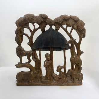 Photo of a wood Nativity scene depicting the Holy Family in a hut with animals looking on from the trees.