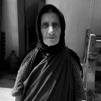 Black and white photo of a woman standing with hands open at her sides.