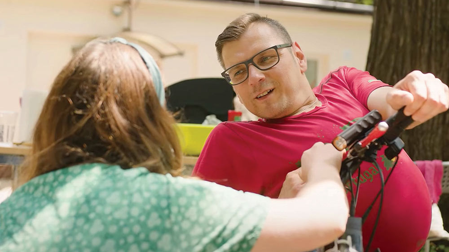 A Klika volunteer chats with a guest during a picnic