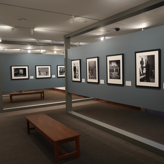 Color photo of a museum gallery with black and white photographs on exhibit.