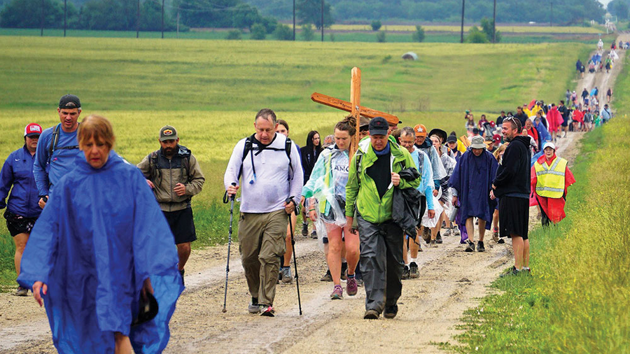 Participants the 14th annual Father Kapaun Pilgrimage walk down a country road