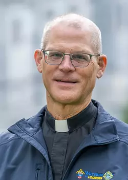 WTL Staff, Spiritual Director, Monsignor Jeffrey Laible, Col/CH/USAF, Ret. wearing a blue jacket and glasses.