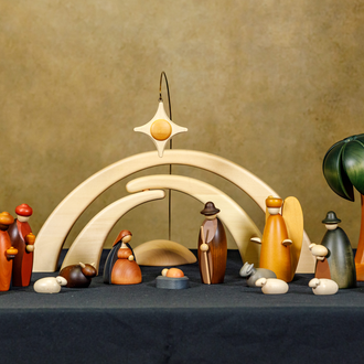 Wood painted Nativity from Germany with the Holy Family, angel, 2 Magi, 2 shepherds, 3 sheep, an ox, a donkey, a palm tree, 2 arches, and a star.