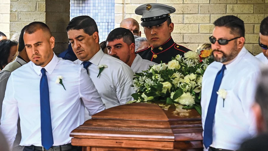 Pallbearers, including U.S. Marine Christian Garcia, carry the caskets of Irma and Joe Garcia