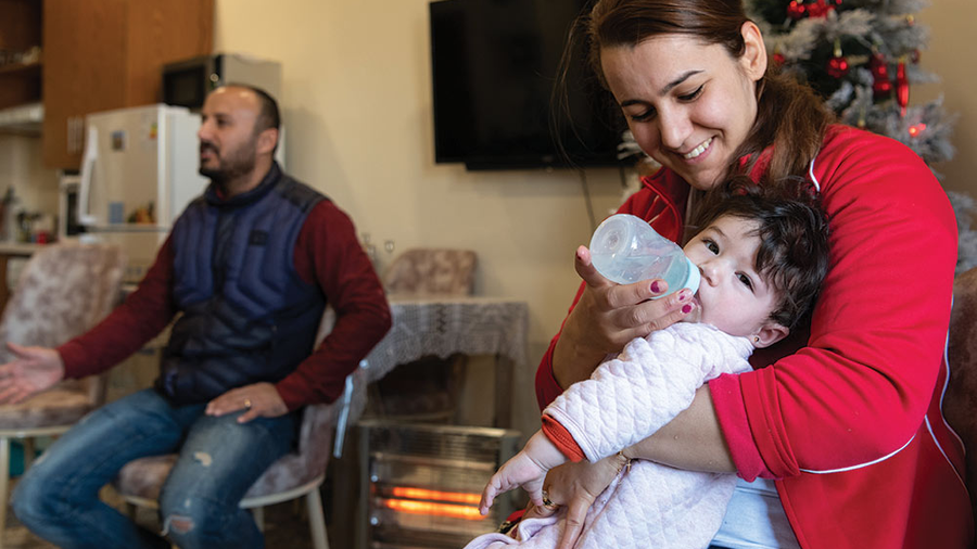 Soleen Sami Ibrahim feeds her baby in her family’s new apartment in McGivney House in Erbil, Iraq