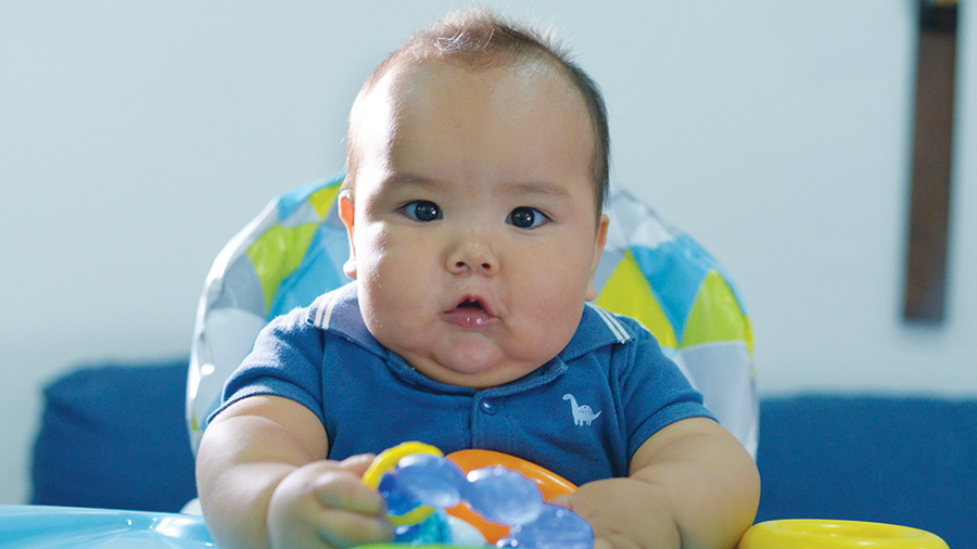 José Miguel plays in his high chair in December 2022.
