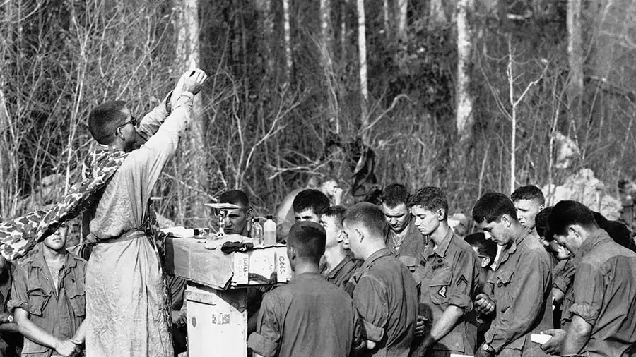 Army Chaplain (Maj.) Charles Watters elevates the host during a Holy Week liturgy for paratroopers of the 173rd Airborne Brigade in Vietnam in March 1967. (AP Photo/Horst Faas)