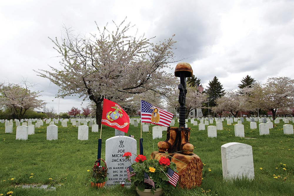 A battlefield cross carved by Anthony Marquez stands by the grave of Marine Lance Cpl. Joe Jackson in Tahoma National Cemetery in Yakima, Wash. Jackson was killed by an improvised bomb while conducting combat operations in Helmand Province, Afghanistan, on April 24, 2011.