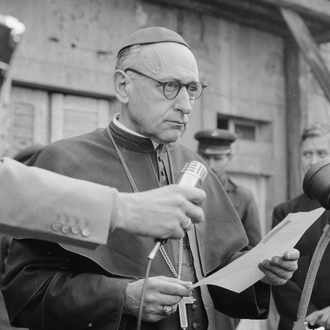 A black and white photograph of Cardinal Mindszenty with a man holding a microphone for him.