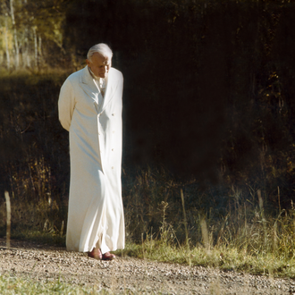 Pope John Paul II walks down a gravel path