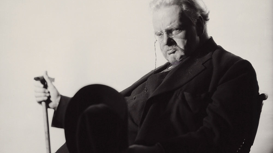 Chesterton sits for a portrait by British photographer Howard Coster