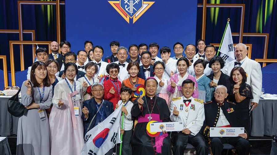 Delegates from the Republic of Korea take a photo together after the States Dinner on Aug. 6, making a gesture, popular in Korea, called the finger heart. Seated in the front row (left to right) are Bishop Titus Seo Sang-bum of the Military Ordinariate of Korea; Maj. Gen Shin Kyoung-soo, the jurisdiction’s territorial deputy; and retired Marine Col. Charles Gallina, who has worked closely with the Knights in Korea for many years. (Photo by Tamino Petelinšek)