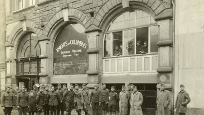 U.S. soldiers and K of C field secretaries stand outside of a K of C hut in Andernach, Germany, circa 1919