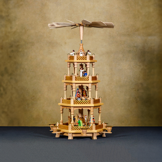 Photo of a wood Nativity with the Holy Family and other figures set on tiers of a pyramid. 