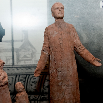 Small Statue of Father Mcgivney with a mother and her children.