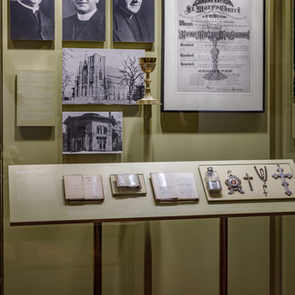 Wall case of Father Michael J. McGivney gallery discussing his pastoral work in New Haven, Connecticut. 