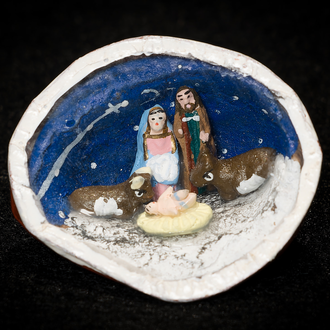 Image of Nativity scene featuring the Holy Family, donkey, and ox contained within a walnut shell.