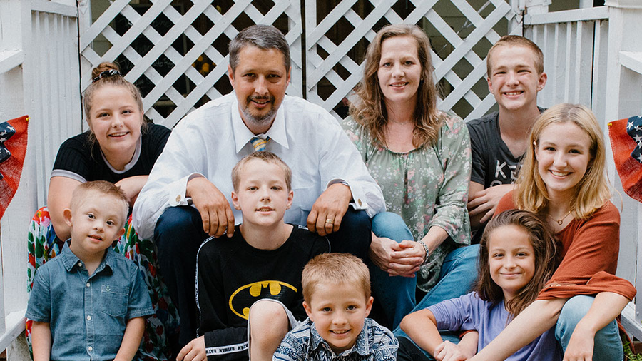 Dan and Michelle Schachle are pictured with seven of their 13 children, including Mikey, outside of their Tennessee home.